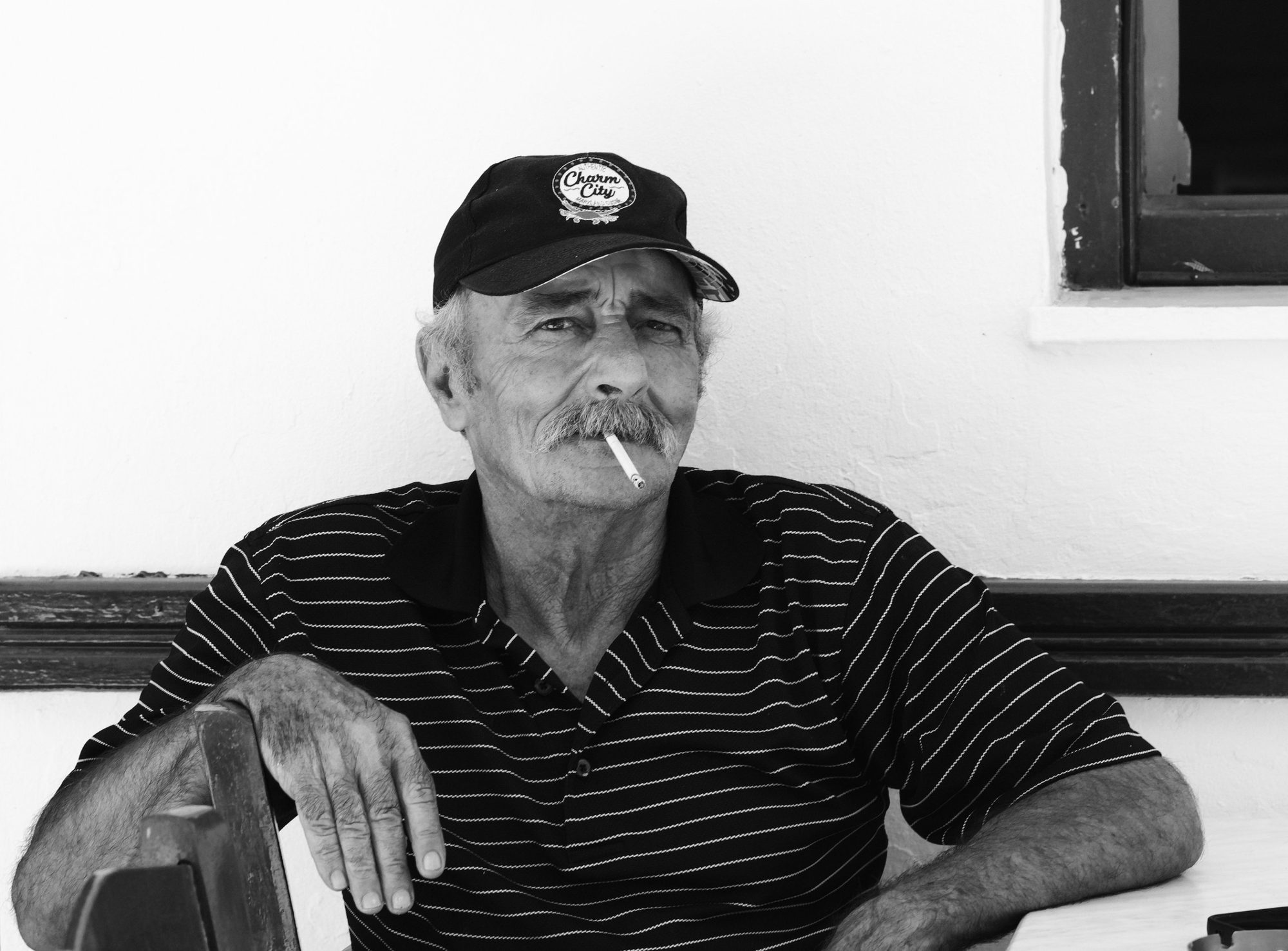 Older man in a cap with a cigarette, black and white